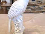 a white bird sitting on top of a tree stump