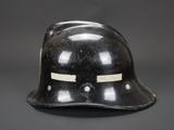 an old black helmet on a gray background with a sticker on the side