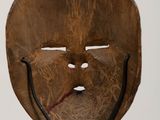 a wooden mask on a metal stand with a white background