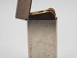 a silver lighter with a lighter in it on a white surface