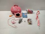 a pink case with a camera and other items on the table