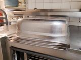 a metal pan sitting on top of an oven in a kitchen