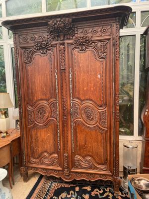 a large wooden armoire in the corner of a room