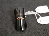 une bague noire sertie d'une pierre rose, avec une étiquette de prix
