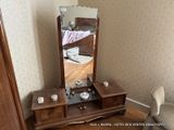 une photo d'une chambre à coucher avec une commode et un miroir