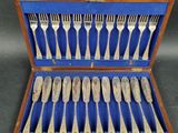 silverware in a wooden case with blue lining on a table