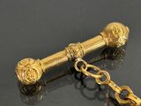 a gold keychain with a key on a black surface