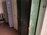 une rangée de cabines vertes et blanches dans des toilettes publiques