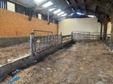 a barn that has a lot of hay on the ground