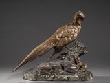 bronze sculpture of a pheasant and a lion on a marble base