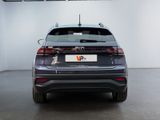 the rear end of a grey car parked in a garage