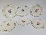 six plates with floral designs are arranged on a white surface