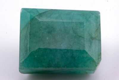 gros plan d'une pierre d'émeraude verte sur une surface blanche