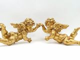 une paire de figurines d'anges en or sur fond blanc