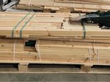 several pieces of wood are stacked on pallets in a warehouse