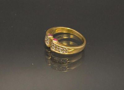 a gold ring with a pink stone on a black surface