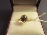 a gold ring with a black diamond in it in a box