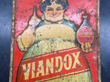 une vieille affiche en tôle représentant une femme tenant une bouteille de bière