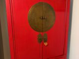 une photo d'une armoire rouge dans une pièce avec un miroir