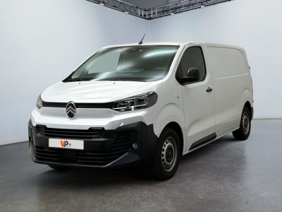 La camionnette blanche est garée dans une grande pièce.