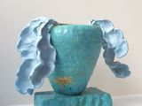 un vase bleu contenant une fleur, posé sur une table
