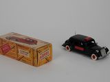 a small black toy car next to a box of cigarettes