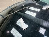 a black car parked in a parking lot next to a parking meter