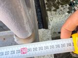 someone is measuring the height of a pipe with a tape measure