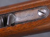 a close up of a wooden rifle with a metal handle