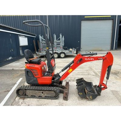 a small red excavator parked in a parking lot