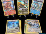 Quatre cartes Pokémon différentes sont représentées en ligne sur un fond noir.