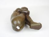 a bronze statue of a man laying on the ground