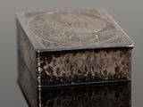 a silver box sitting on top of a black surface