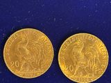 two gold coins, one of which is a rooster and the other of which is a rooster