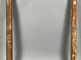 an old picture frame sitting on top of a table next to a wall