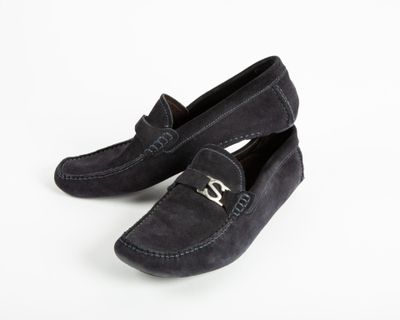 black sued slippers with a metal buckle on the front