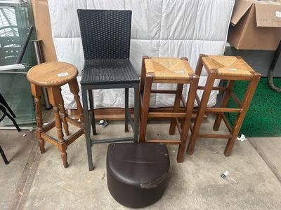 four stools and a chair sitting on the ground