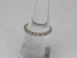 a diamond ring sitting on top of a clear glass bottle