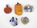 quatre œuvres d'art en verre sont exposées sur une surface blanche