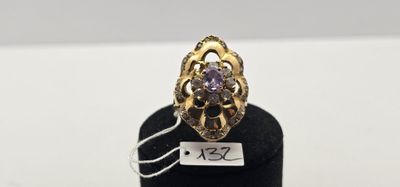 un gros plan d'une bague en or sertie d'une pierre violette