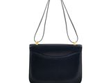 a black leather shoulder bag with a gold handle
