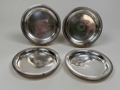 three silver plated dishes on a table with a white background