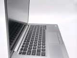 a silver laptop computer sitting on top of a white table