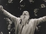 black and white photograph of a man with a long beard standing in front of a group of men