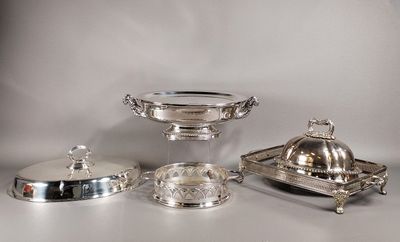 des assiettes et des plateaux en métal argenté posés sur une table avec un fond blanc