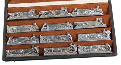 Suite de 12 PORTE-COUTEAUX en métal argenté à décor stylisé …