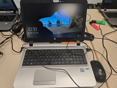 un ordinateur portable posé sur un bureau en bois
