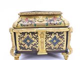 a gold and black box with flowers on it