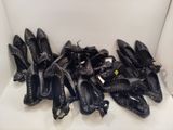 beaucoup de chaussures noires posées sur une chaise blanche