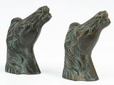 pair of bronze sculptures of a horse ' s head on a white background